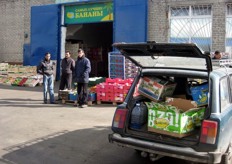 Er zijn mensen die agf-producten in hun auto laden.