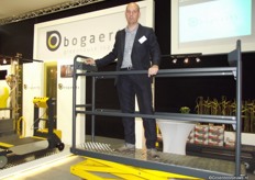 "Joris Bogaerts van Bogaerts Greenhouse Logistics op een demo van het nieuwste product uit het assortiment: Qii- lift. Joris: "Deze heeft heel wat voordelen ten opzichte van de voorlopers. Ik noem er een aantal: twee poortjes (zodat er niet meer tussen de planten en kar hoeft gelopen te worden), verstevigde snelheidsregelknop, voetpedaal voor starten en stoppen, tandwielaandrijving ipv kettingaandrijving, snelheidsgeregelde hef- en daalbeweging, snellere hef- en daalbeweging"."