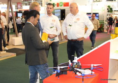 Luuk Jumelet en Martin Meuldijk geven uitleg over Auxin bij het hoekje van de stand van Royal Brinkman dat daarop gericht was. Op de voorgrond een drone van Florinco die data levert aan het platform Auxin.