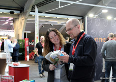 Bij de stand van GroentenNieuws, AGF en HortiDaily konden weer handboeken opgehaald worden. Hier legt Andrea van der Hoven beursbezoeker Austin van Organifarms uit wat hij allemaal in de handboeken kan vinden. 